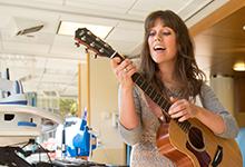 一位SPU音乐疗法的校友在医院里弹吉他.